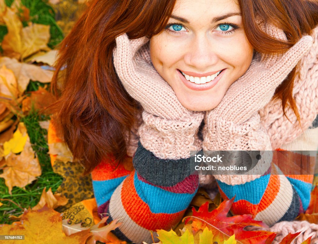 Souriante aux cheveux rouges femme jeter les feuilles d'automne - Photo de 20-24 ans libre de droits