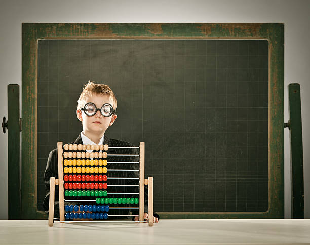 istock young serious scientist child with abacus and copyspace blackboa 157684402