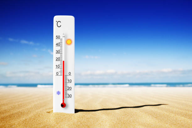 istock Hot summer day. Celsius scale thermometer in the sand. Ambient temperature plus 20 degrees 1576844556
