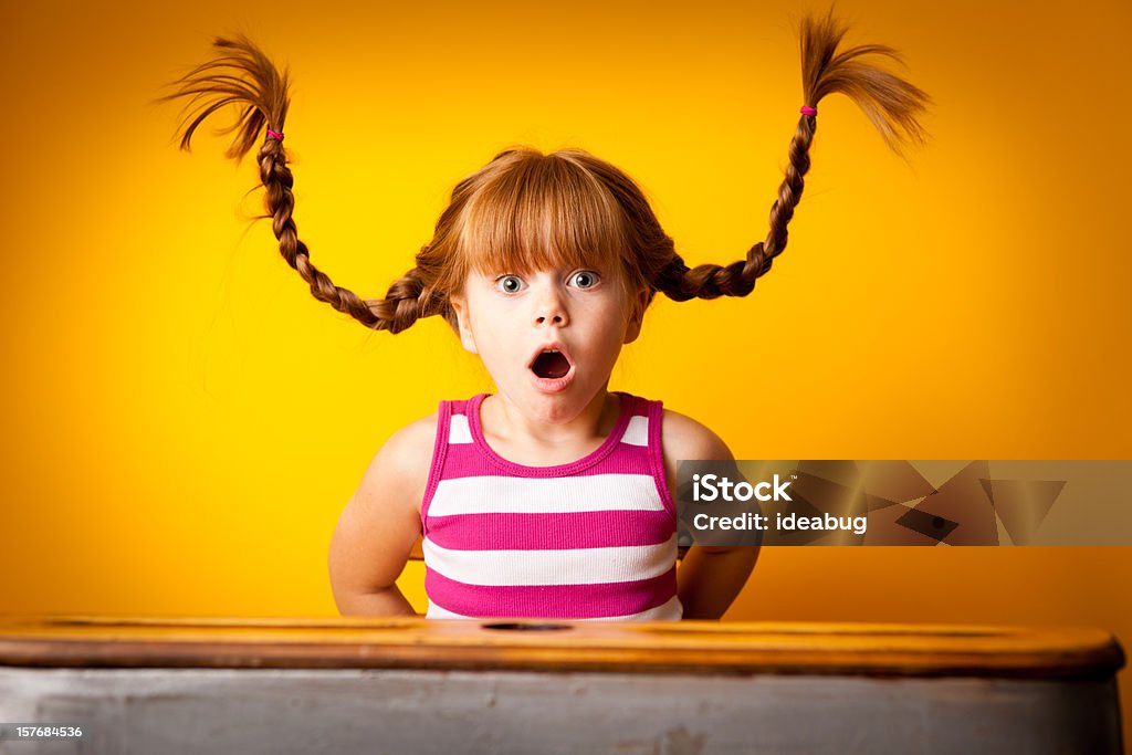 Sorprendido niña de pelo roja con mallas para arriba en la escuela escritorio - Foto de stock de Niño libre de derechos