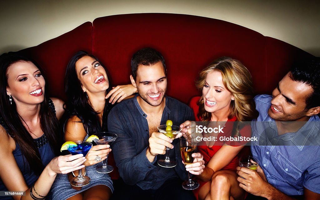 Happy young couples enjoying drinks at a nightclub Group of young boys and girls with their drinks at a nightclub Drinking Stock Photo