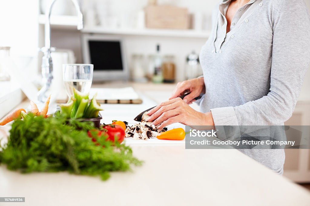 Mature woman cutting vegetables in the kitchen  Cooking Stock Photo