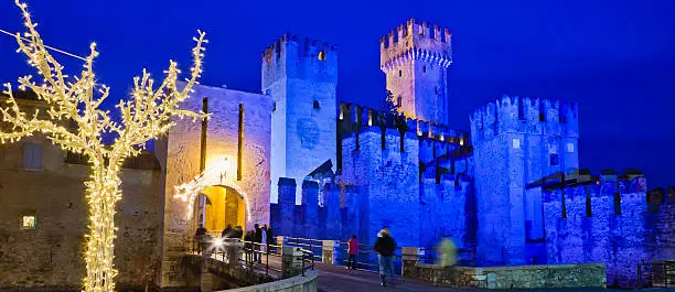 Evocative view of Sirmione at Christmas. The imposing thirteenth-century castle in the photo is called Rocca Scaligera and dominates the town. Sirmione is one of the beautiful villages on the shores of Lake Garda. Sirmione, Lake Garda, Italy. Canon EOS 5D Mark II.