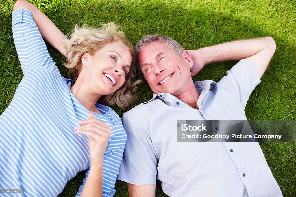 朗らかマチュアカップルが一緒に過ごす時間の芝生 - 横たわるのロイヤリティフリーストックフォト