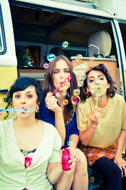 istock Three vintages girls making bubbles outdoors in summer, vertical. 157684970