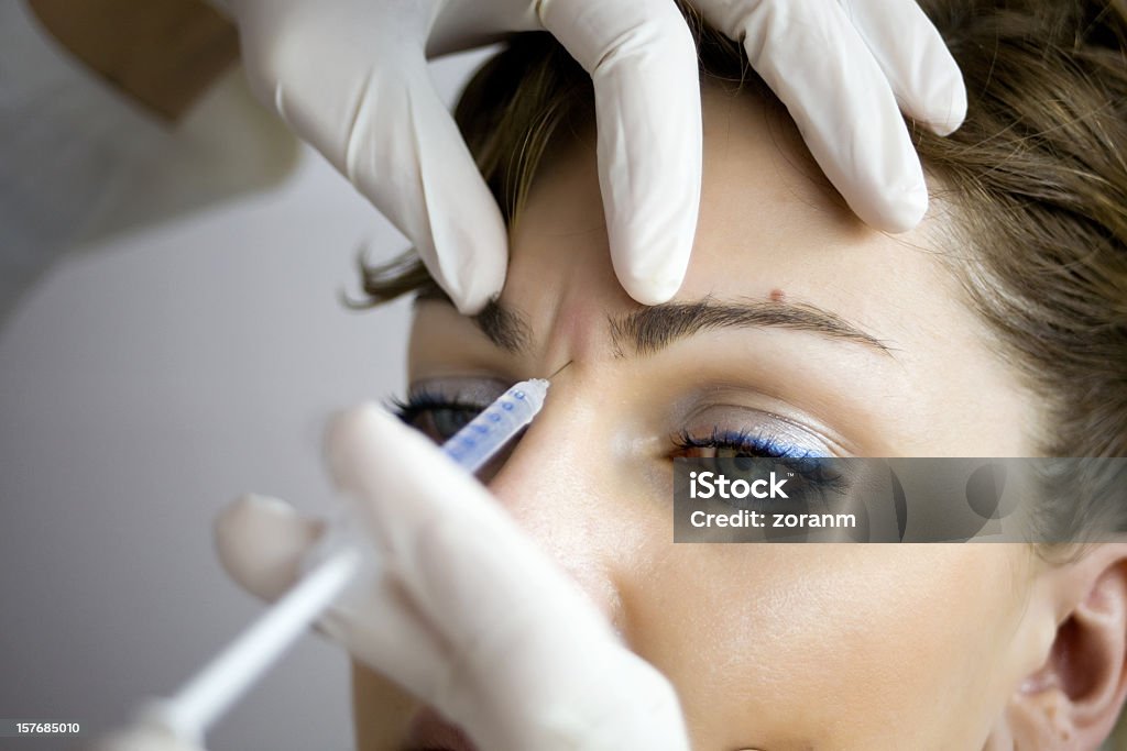 A woman having Botox injections Injecting botox in forehand Botulinum Toxin Injection Stock Photo