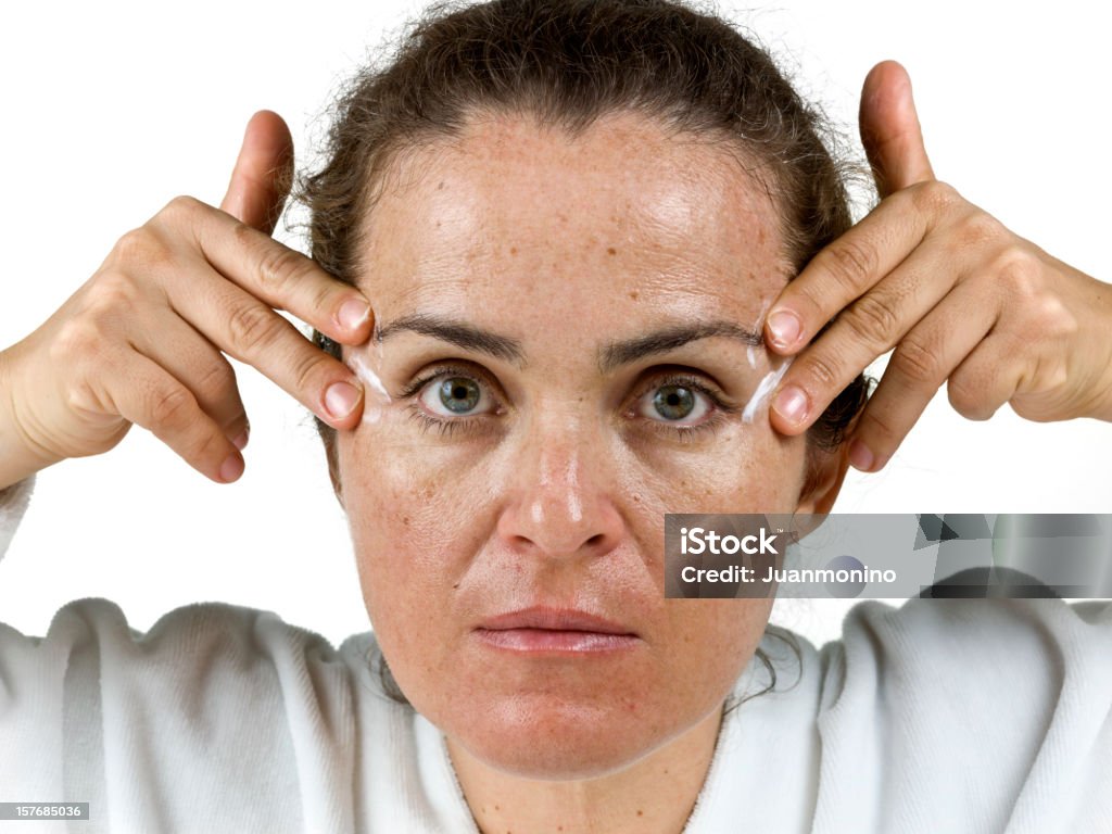 applying cream to her wrinkles  Moisturizer Stock Photo