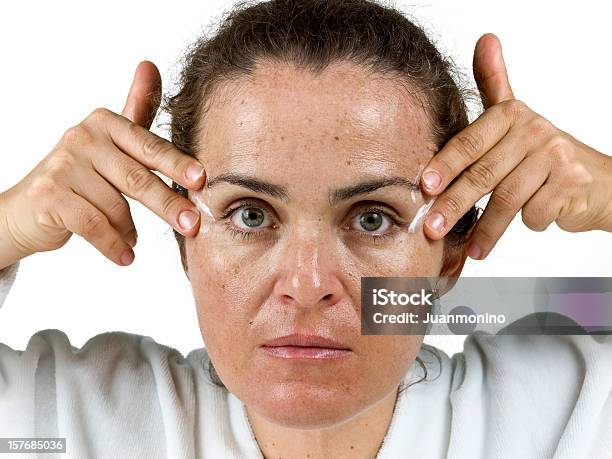 Applying Cream To Her Wrinkles Stock Photo - Download Image Now - Moisturizer, Wrinkled, Massaging