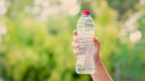 istock Hand holding a bottle of water in nature 1576851925