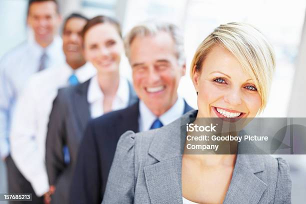 Beautiful Corporate Woman Smiling With Her Team In A Row Stock Photo - Download Image Now