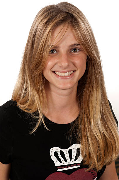 Smiling Teenage Girl Smiling Blonde Caucasian Teenage girl smiling looking at the camera on white background (the tshirt design has been modified from original) 15 year old blonde girl stock pictures, royalty-free photos & images