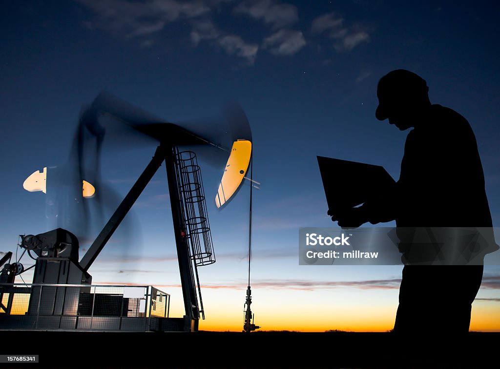 Ölquelle Pumpjack im Morgengrauen mit Arbeiter - Lizenzfrei Geologe Stock-Foto