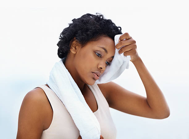 istock Woman wiping sweat off forehead after workout 157685489