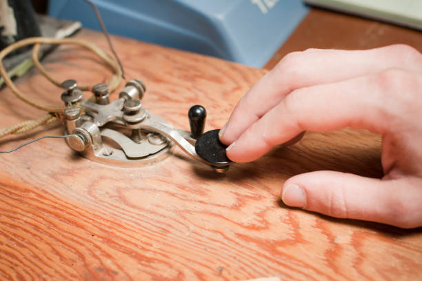 Telegraph Key A man works a telegraph key at a desk. telegram machine photos stock pictures, royalty-free photos & images