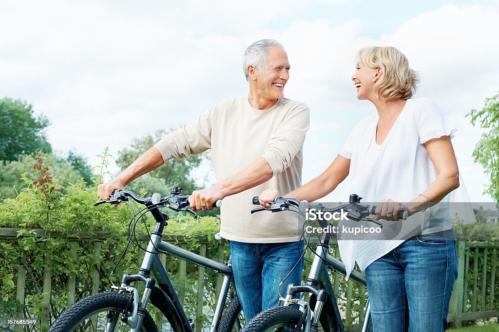 Happy senior couple with bicycles in countryside Portrait of a happy senior couple with bicycles in countryside 40-49 Years Stock Photo