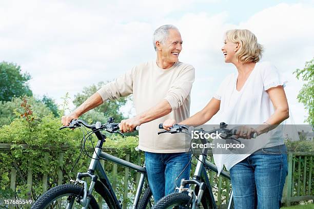 Happy Senior Couple With Bicycles In Countryside Stock Photo - Download Image Now - 40-49 Years, 50-59 Years, Active Lifestyle