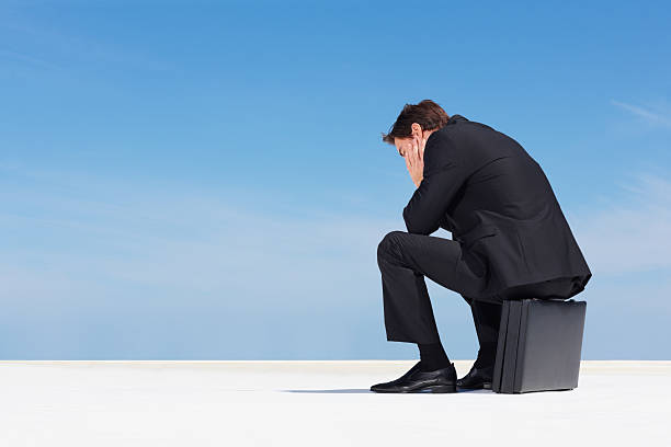 istock Depressed business man sitting on briefcase - copyspace 157685566