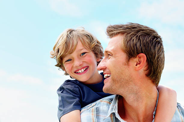 istock Cheerful mature man carrying his son on back 157685733