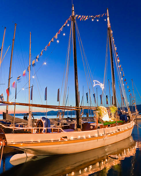 парусное судно оформлены на рождество, озеро гарда - lake garda sunset blue nautical vessel стоковые фото и изображения
