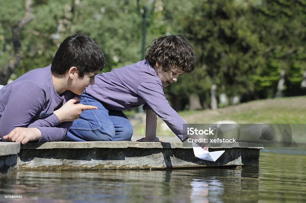 Два брата играть с бумаги лодок, - Стоковые фото 10-11 лет роялти-фри