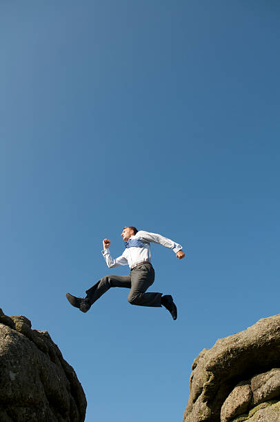 istock Businessman Leaps Between Big Boulders 157685963