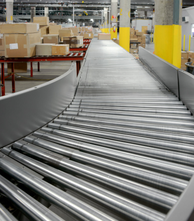 Warehouse with conveyor rollers and boxes.