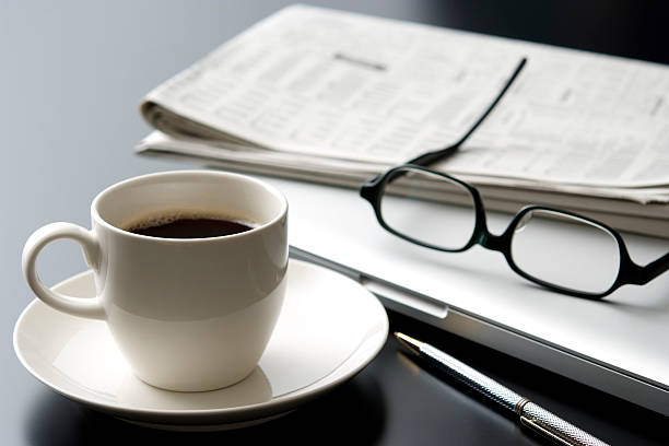 laptop e uma xícara de café na mesa de escritório - paper glass imagens e fotografias de stock