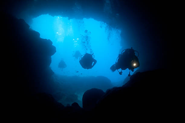 Cave Divers diving into the Santa Maria Caves, Comino, Malta stock photo