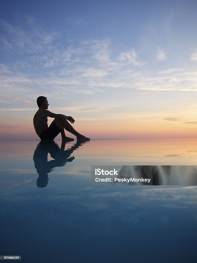 Silhouette eines Mannes, spiegelt sich in den Infinity-Pool bei Sonnenuntergang - Lizenzfrei Männer Stock-Foto