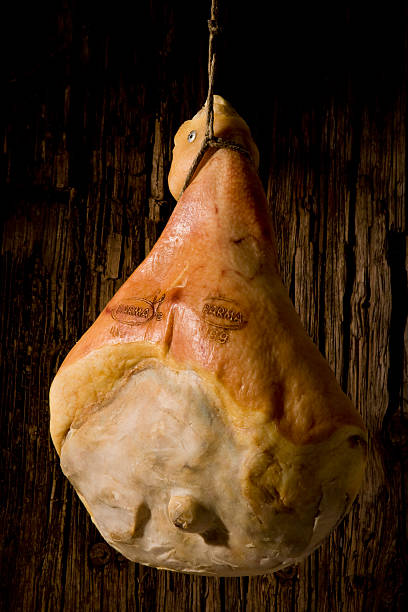Parma ham hanging Prosciutto di Parma hanging from an old wood wall parma ham stock pictures, royalty-free photos & images