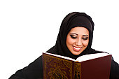 Happy Arabic girl reading the holy Koran