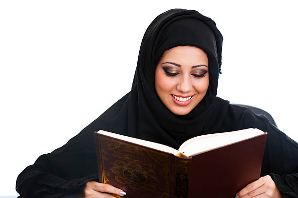 Arabic girl reading the Koran  middle eastern ethnicity mature adult book reading stock pictures, royalty-free photos & images