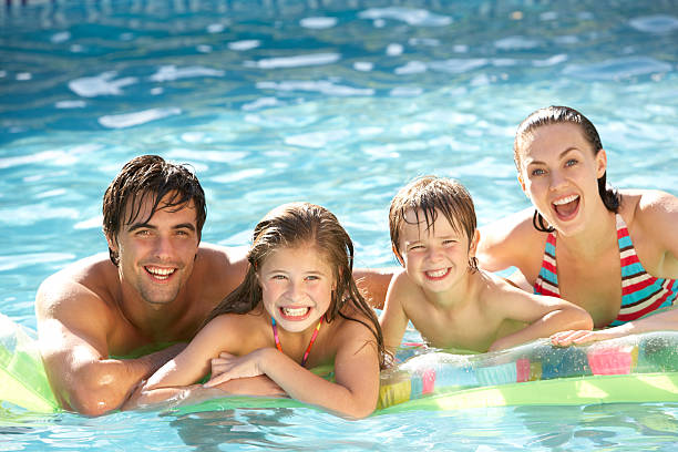 familia joven relajante en la piscina - inflatable raft fotos fotografías e imágenes de stock