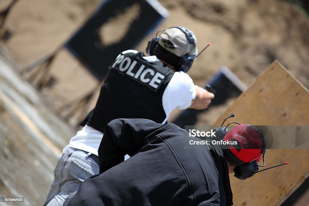 Polizisten Officer Shooting 9 mm-Pistole mit Fitnesstrainer - Lizenzfrei Sportschießen Stock-Foto