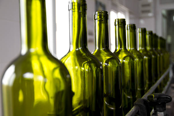 Wine bottles colored green on an assembly line wine bottling bottling plant stock pictures, royalty-free photos & images