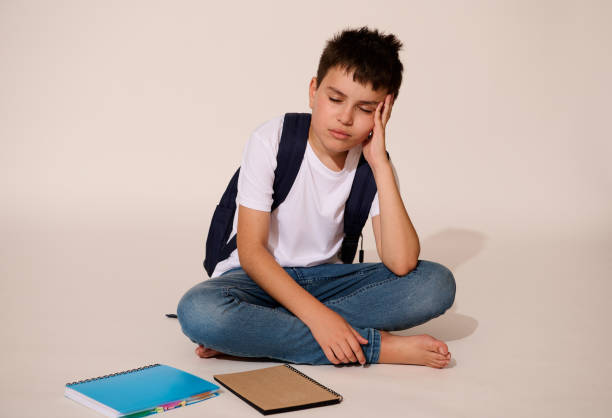 istock Upset teenager, school boy, holding head, demotivated , feeling difficulties with learning and problems at school 1576873500