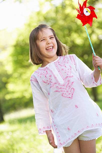 istock Young Girl Walking Through Summer Field Carrying Windmill 157689410