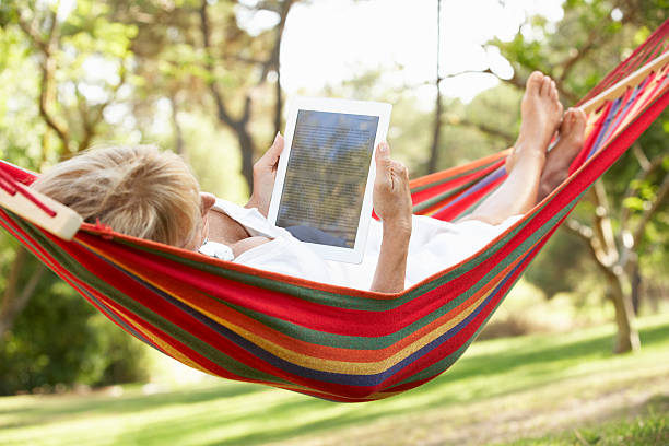 istock Senior Woman Relaxing In Hammock With  E-Book 157689512