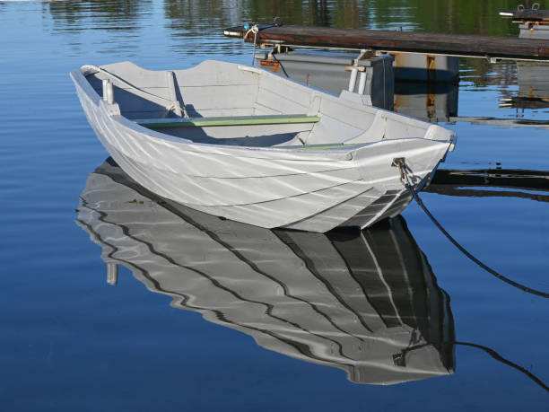 istock A white row boat tied to a dock in summer. 1576897585