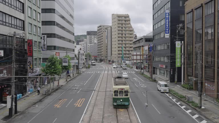 People in Nagasaki Japan commuting to workplace or traveling by using tram or streetcar and bus as a normal daily transportation vehicle. Japan urban transportation lifestyle concept.