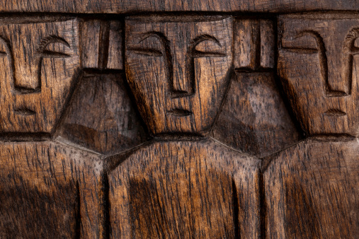 Detail of three wood carved men. Exterior building decor, Philippines.