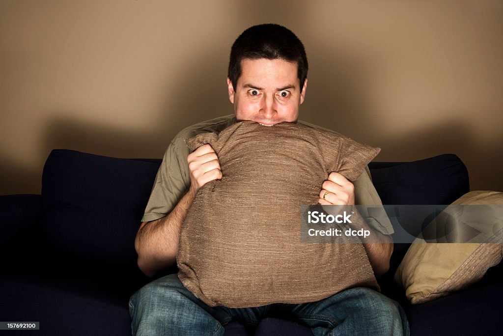 Homem pedaços de almofada com medo enquanto assiste a programas de televisão - Royalty-free Ver Televisão Foto de stock