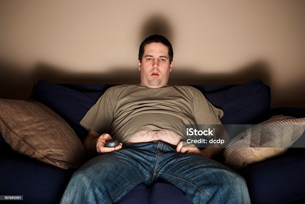 Overweight slob watching TV  Laziness Stock Photo