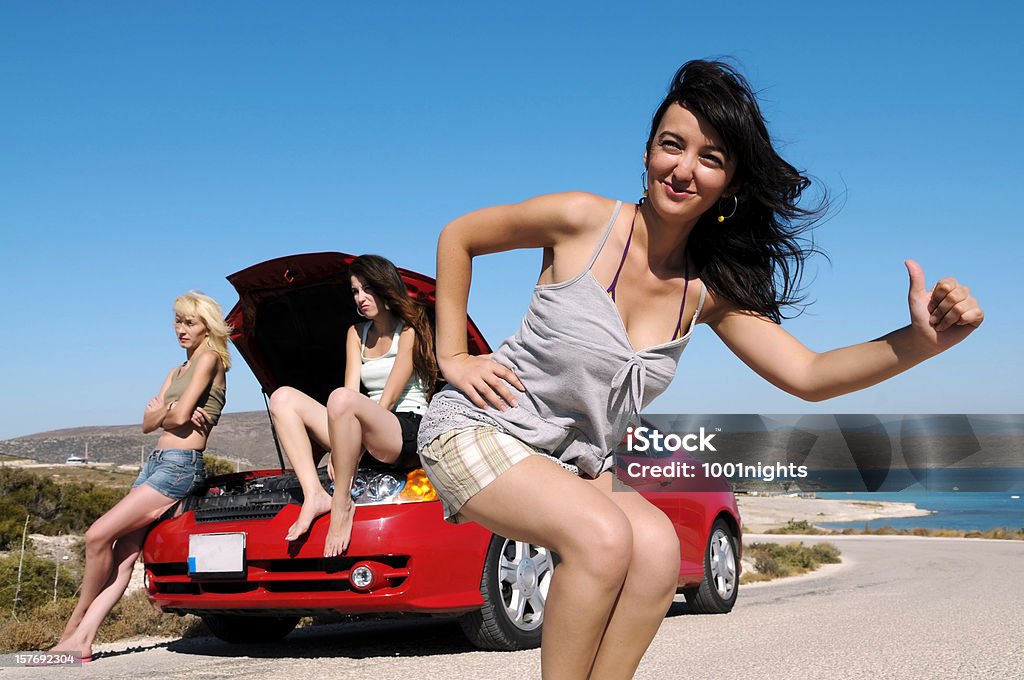 Tre donne Fare l'autostop in piedi accanto a noleggio con cappuccio sollevato - Foto stock royalty-free di Donne