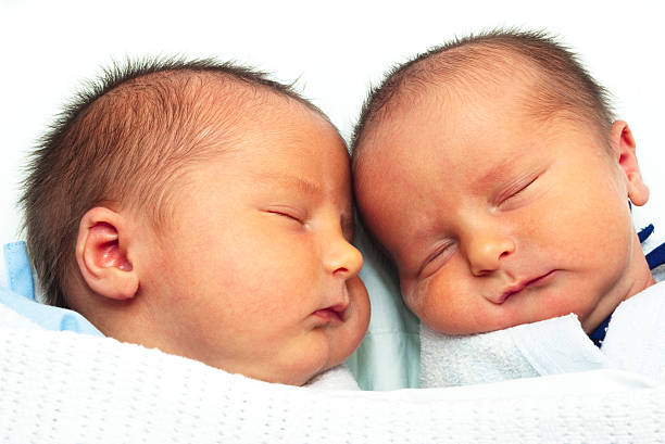 istock Identical twin baby boys lying close together 157692448