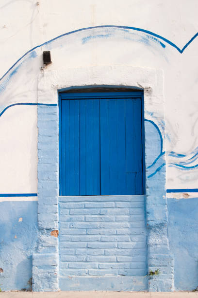 Yellow house with blue wooden door in San Francisco de Campeche, Mexico