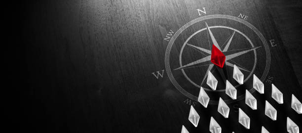 Leadership Concept Red Paper Boat Leading A Fleet Of Small White Boats With Compass Icon On Modern Black Wooden Table - Leadership Concept overseeing stock pictures, royalty-free photos & images
