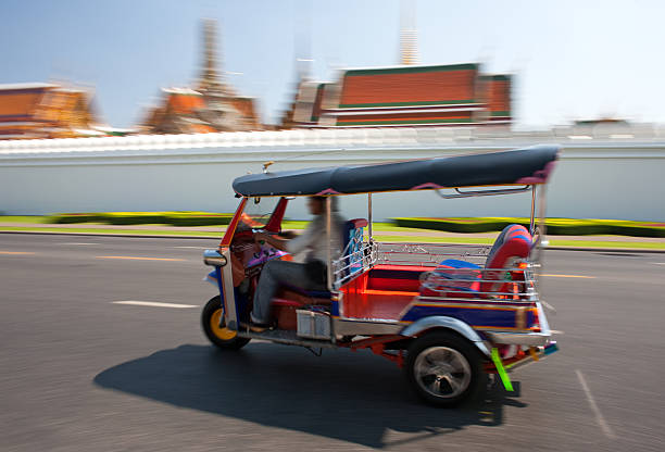Bangkok, Thailand- 13 Feb, 2023: Traditional tuk-tuk on the road in Bangkok. Tuk tuks are motorized 3-wheeled rickshaws that ferry passengers around
