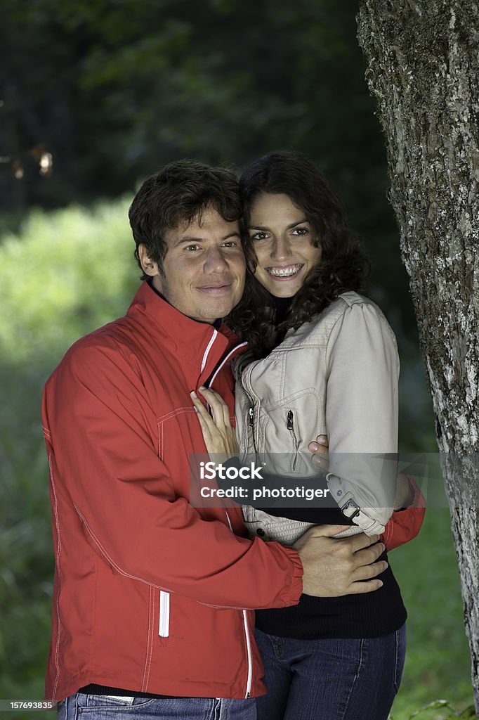 Счастливая пара, помимо дерево - Стоковые фото 20-29 лет роялти-фри