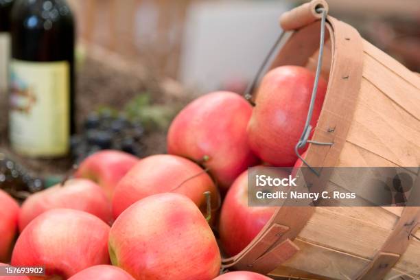 Photo libre de droit de Pommes Débordant De Panier Bouteille De Vin En Arrièreplan banque d'images et plus d'images libres de droit de Agriculture